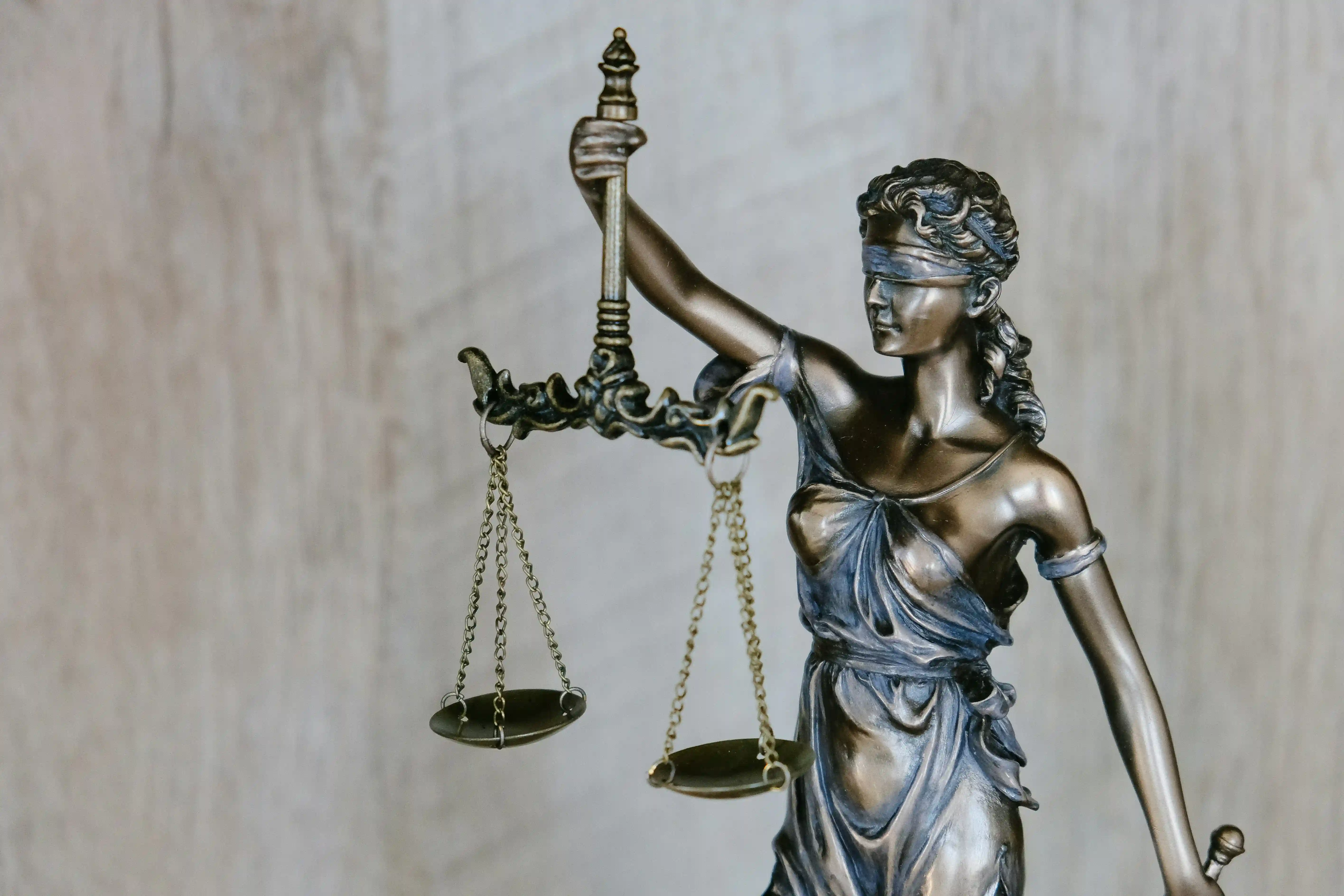 Femme tenant une balance et une statue dépée pendant la journée